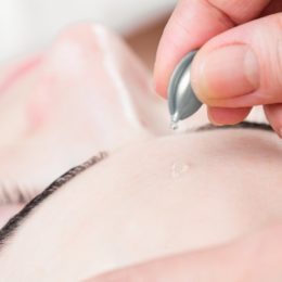 Serum capsule facial treatment of young woman in spa salon